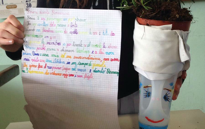 Pagina scritta da un bambino e un vaso costruito con una vecchia bottiglia di detersivo