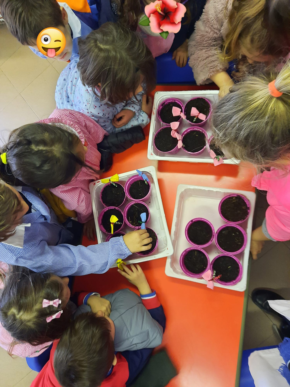 Bambini decorano i loro vasetti pieni di terra