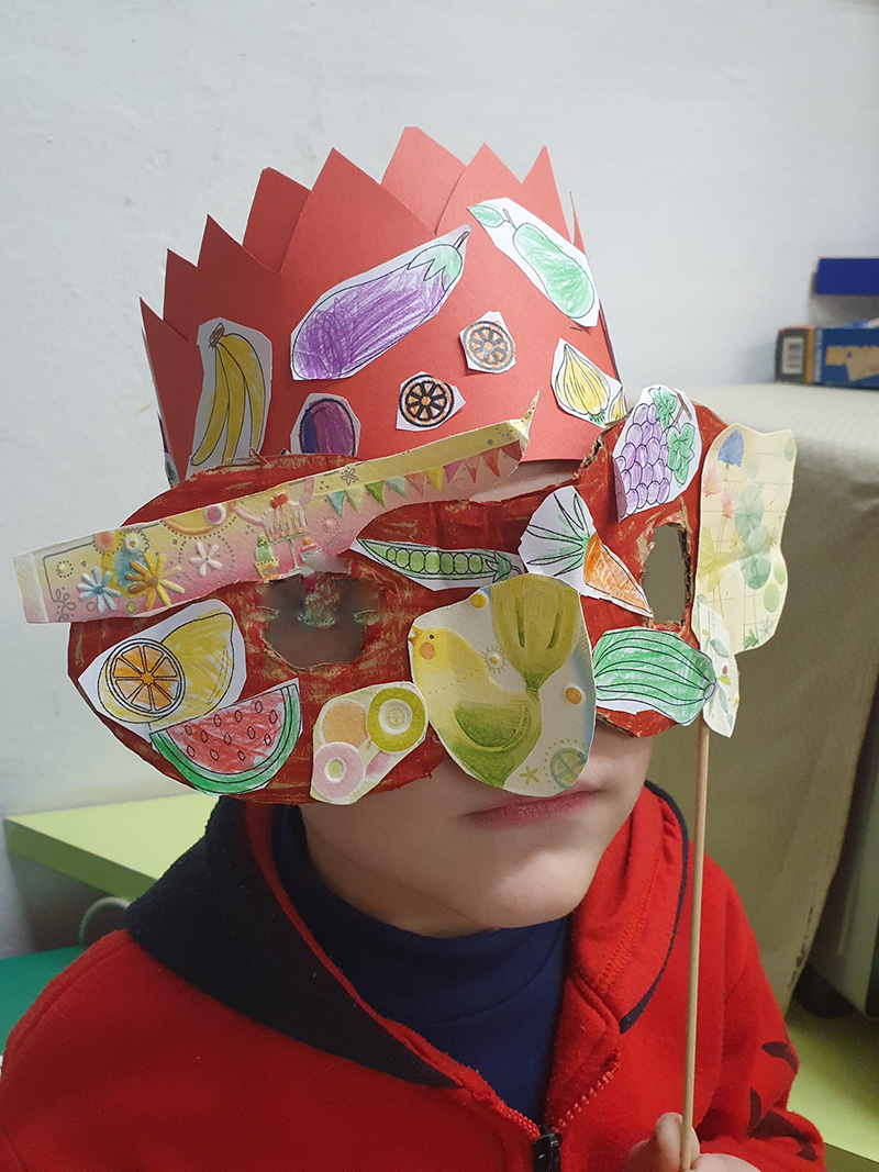 Bambino con cappello e maschera di carnevale