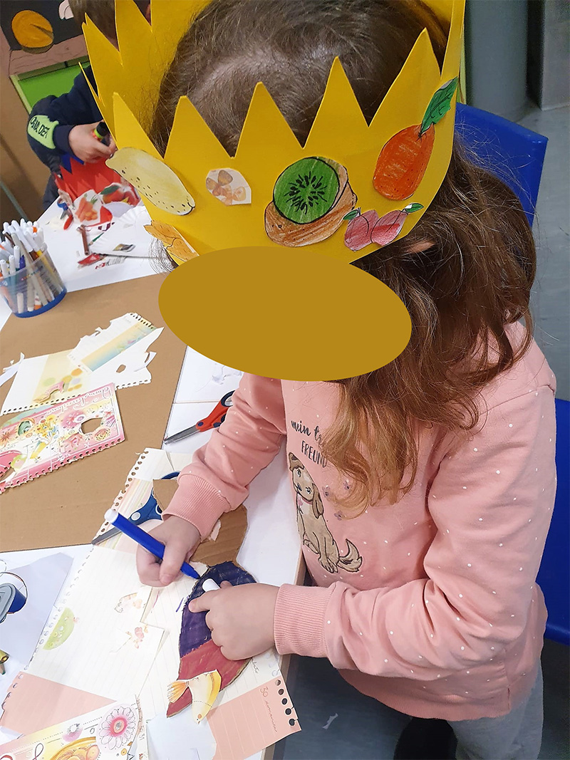 Bambina con corona decorata che disegna